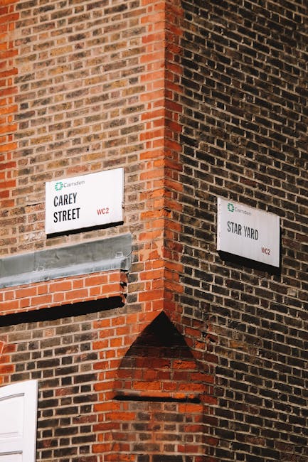 Close-up view of a brick building corner displaying two street signs, one labeled 'Carey Street' and the other 'Star Yard,' both with the Camden Council logo and WC2 postal code. The signage is mounte